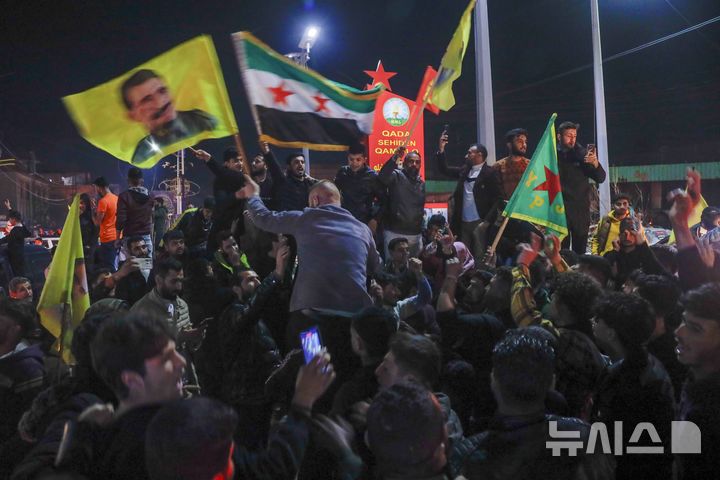 [카미실리=AP/뉴시스] 10일(현지 시간) 시리아 북동부 카미실리에서 주민들이 시리아 과도정부와 북동부 지역을 장악한 시리아민주군(SDF) 간 역사적인 협정 체결을 축하하고 있다. 앞서 아마드 알샤라 시리아 과도정부 대통령과 마즐룸 압디 SDF 사령관은 두 세력을 통합하는 합의서에 서명했다. 2025.03.12.