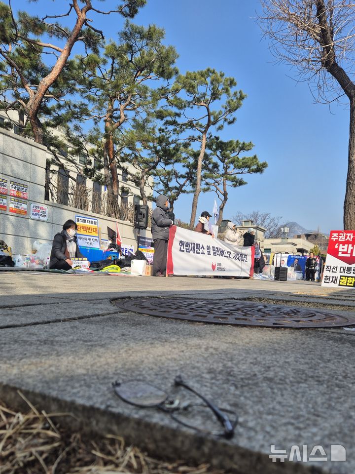 [서울=뉴시스] 이명동 기자 = 윤석열 대통령의 탄핵 심판 선고를 앞둔 11일 서울 종로구 헌법재판소 앞에 길가에 부러진 안경이 널브러져 있다. 2025.03.11. ddingdong@newsis.com 