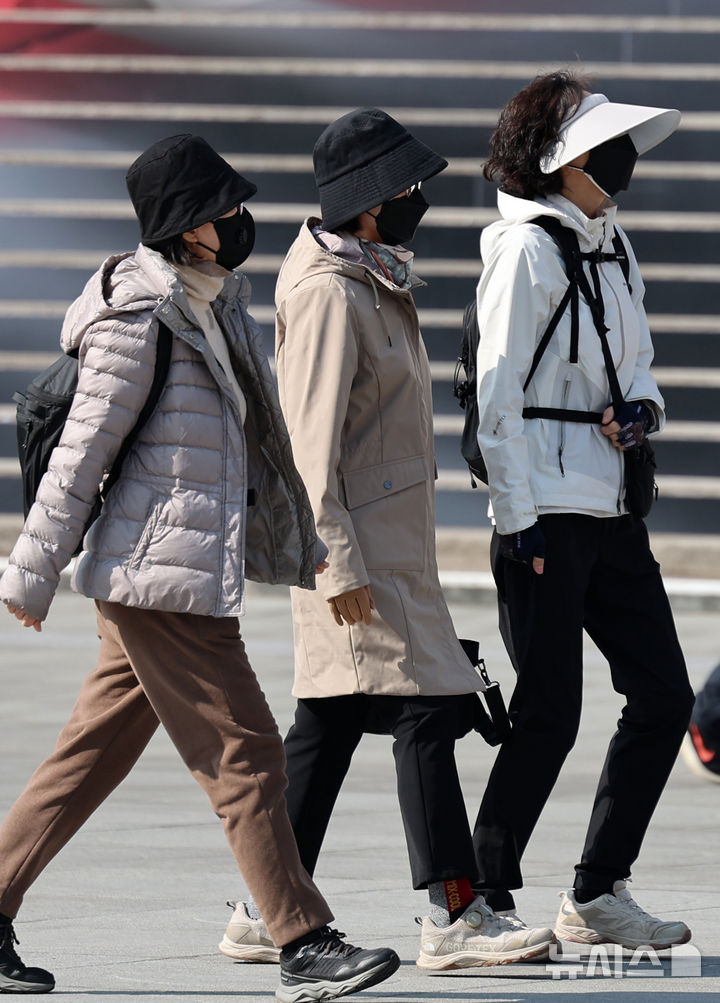 [서울=뉴시스] 이영환 기자 = 서울과 수도권에 미세먼지 비상저감조치가 발령된 11일 서울 종로구 광화문광장에서 마스크를 쓴 시민들이 걸어가고 있다. 2025.03.11. 20hwan@newsis.com