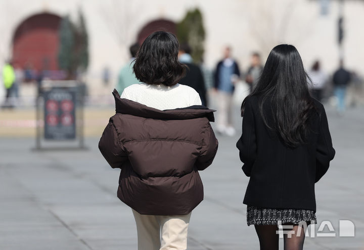 [서울=뉴시스] 김진아 기자 = 낮 기온이 15도까지 오르는 등 포근한 날씨를 보인 11일 서울 광화문광장에서 시민들이 외투를 벗고 있다. 2025.03.11. bluesoda@newsis.com