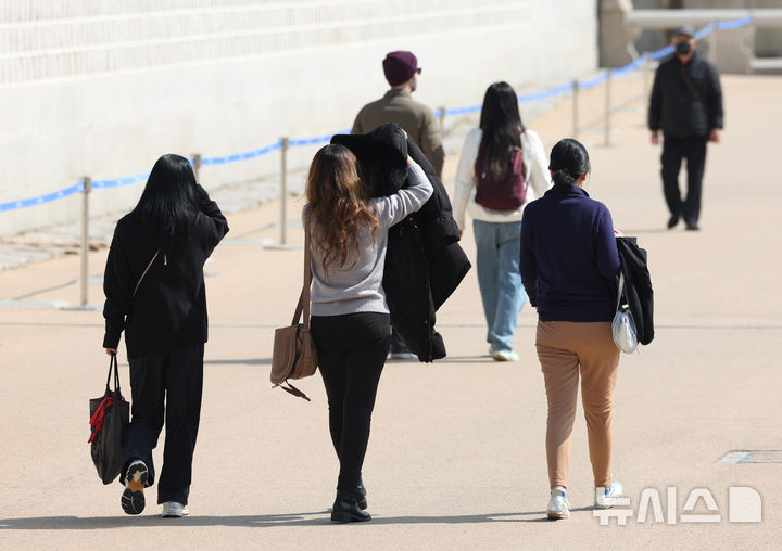 [서울=뉴시스] 김진아 기자 = 낮 기온이 15도까지 오르는 등 포근한 날씨를 보인 11일 서울 광화문광장에서 시민들이 외투를 들고 걷고 있다. 2025.03.11. bluesoda@newsis.com