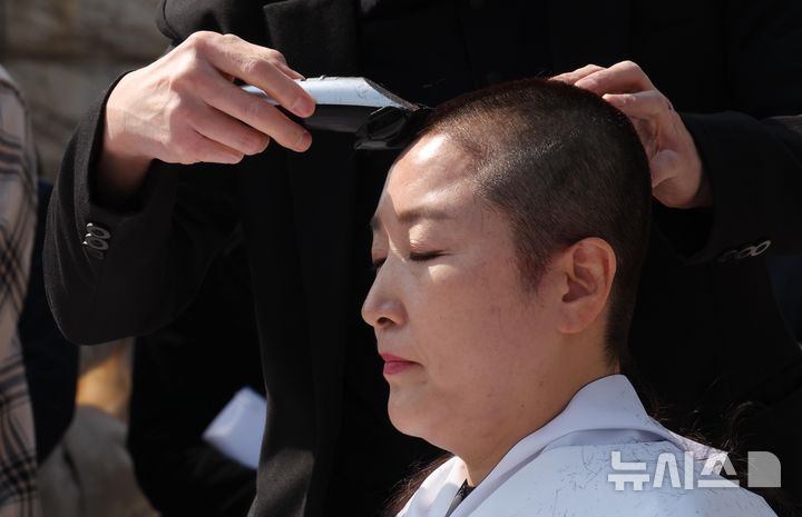 [서울=뉴시스] 조성봉 기자= 전진숙 더불어민주당 의원이 11일 오후 서울 여의도 국회 본청 계단 앞에서 헌법재판소의 윤석열 대통령에 대한 조기 파면 결정을 촉구하며 삭발하고 있다. 2025.03.11. suncho21@newsis.com