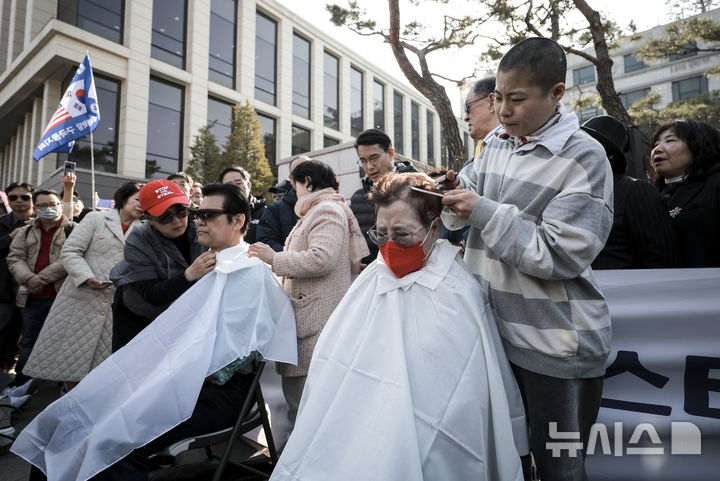 [서울=뉴시스] 정병혁 기자 = 11일 서울 종로구 헌법재판소 앞에서 윤석열 대통령 탄핵에 반대하는 서울특별시교회총연합회, 서울특별시조찬기도회 소속 기독교들인이 삭발을 하고 있다. 2025.03.11. jhope@newsis.com