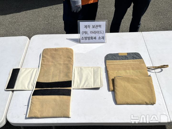 [부산=뉴시스] 이아름 기자 = 부산소방재난본부가 소방관들의 폐방화복(아라미드 소재)으로 자체 제작한 방화팩이 오른쪽에 놓여있다. 왼쪽은 한 재활용 업체가 같은 소재로 제작한 보관팩. 2025.03.12. aha@newsis.com 