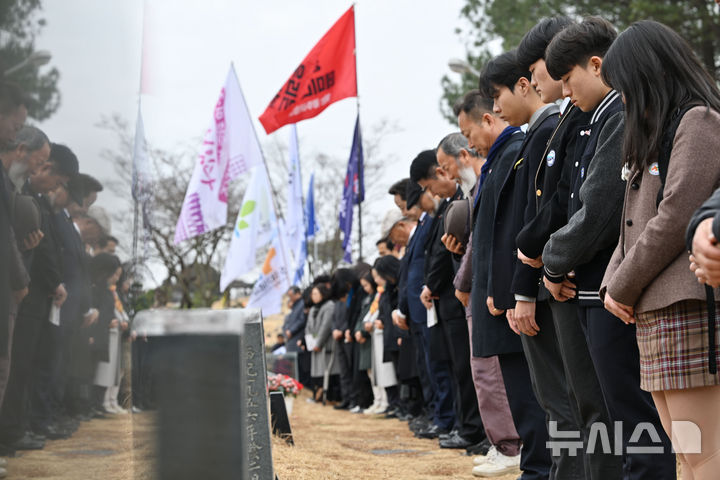 [광주=뉴시스] 이영주 기자 = 제45주년 5·18민중항쟁기념행사위원회가 출범한 12일 오전 광주 북구 망월동 5·18구묘역에서 열리는 출범식에 참여한 유관단체 관계자와 학생들이 오월 영령을 향해 묵념하고 있다. 2025.03.12. leeyj2578@newsis.com