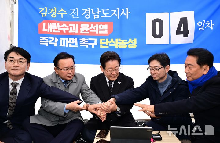 [서울=뉴시스] 황준선 기자 = 박용진(왼쪽부터) 전 더불어민주당 의원, 김부겸 전 국무총리, 이재명 더불어민주당 대표, 김경수 전 경남지사, 이광재 전 국회 사무총장이 12일 오후 서울 광화문 인근 천막에서 윤석열 대통령 파면을 촉구하며 단식 농성에 돌입한 김 전 지사를 응원하며 손을 모아 결의를 다지고 있다. (공동취재) 2025.03.12. photo@newsis.com