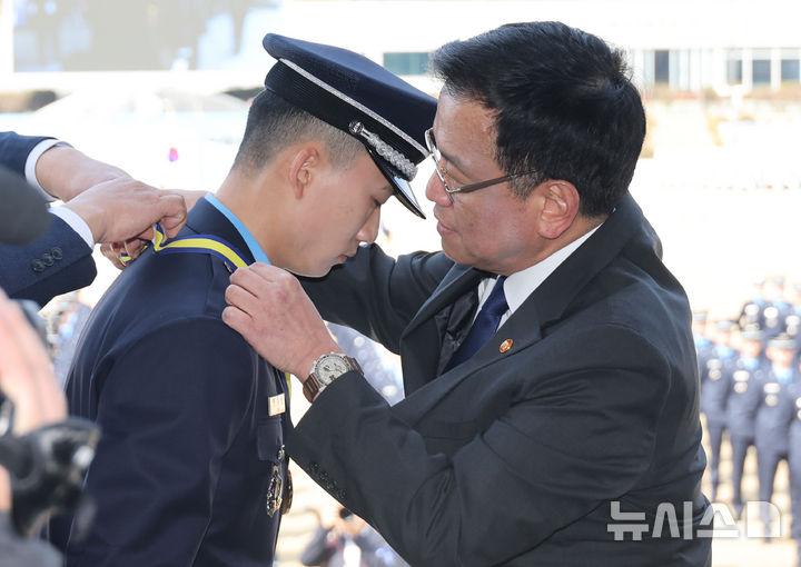 [청주=뉴시스] 조수정 기자 = 최상목 대통령 권한대행 부총리 겸 기획재정부 장관이 12일 청주 공군사관학교에서 열린 제73기 졸업 및 임관식에서 안주선 신임 소위에게 대통령상 메달을 목에 걸어주고 있다. (대통령실통신사진기자단) 2025.03.12. chocrystal@newsis.com