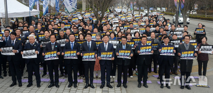 [전주=뉴시스] 김얼 기자 = 김관영(가운데) 전북특별자치도지사를 비롯한 관계자들이 12일 전북 전주시 전북특별자치도청 앞 도로에서 열린 '윤석열 파면 촉구 민주당 전북도당 총집결 당원결의대회'에 참석해 윤석열 파면을 촉구하며 구호를 외치고 있다. 2025.03.12. pmkeul@newsis.com