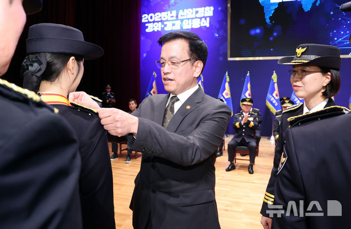 [아산=뉴시스] 조수정 기자 = 최상목 대통령 권한대행 부총리 겸 기획재정부 장관이 13일 충남 아산시 경찰대학에서 열린 2025년 신임경찰 경위·경감 임용식에서 허가영 경위에게 계급장을 달아주고 있다. 2025.03.13. chocrystal@newsis.com