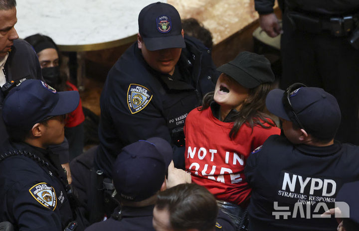 [뉴욕=AP/뉴시스] 13일(현지 시간) 미국 뉴욕 트럼프 타워에서 친팔레스타인 시위를 주도했던 컬럼비아대 대학원생 마흐무드 칼릴의 석방을 요구하며 점거 농성을 한 시위대가 경찰에 연행되고 있다. 2025.03.14.