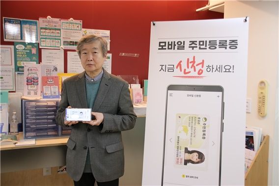 [서울=뉴시스] 대통령 직속 디지털플랫폼정부위원회 김창경 위원장이 전국 모바일 주민등록증 발급 시행 첫 날인 14일 사직동 주민센터에서 QR코드 촬영 방법을 통해 모바일 주민등록증을 발급받았다. (사진=디플정위 제공) *재판매 및 DB 금지