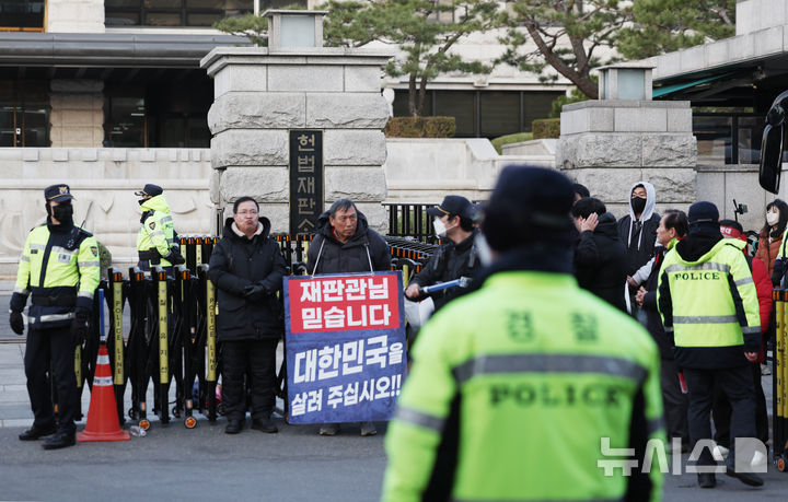 [서울=뉴시스] 김진아 기자 = 윤석열 대통령 탄핵 심판 선고를 앞둔 14일 서울 종로구 헌법재판소 앞에 윤 대통령 지지자들이 손팻말을 들고 있다. 2025.03.14. bluesoda@newsis.com