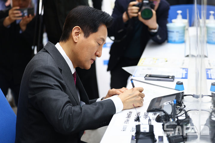 [서울=뉴시스] 고범준 기자 = 오세훈 서울시장이 14일 서울 용산구 남영동 주민센터에서 모바일 주민등록증을 발급 받고 있다. 2025.03.14. (공동취재) photo@newsis.com