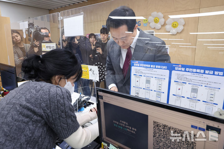 [서울=뉴시스] 고범준 기자 = 오세훈 서울시장이 14일 서울 용산구 남영동 주민센터에서 모바일 주민등록증을 발급 받고 있다. 2025.03.14. (공동취재) photo@newsis.com