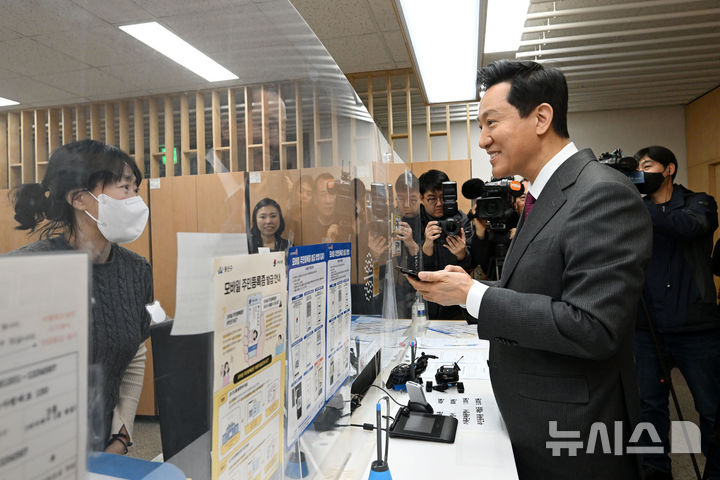 [서울=뉴시스] 고범준 기자 = 오세훈 서울시장이 14일 서울 용산구 남영동 주민센터에서 모바일 주민등록증을 발급 받고 있다. 2025.03.14. (공동취재) photo@newsis.com