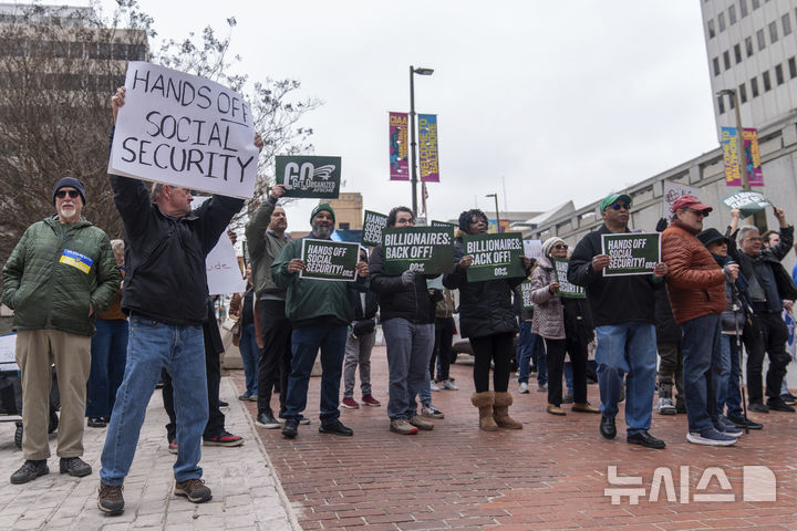 [볼티모어=AP/뉴시스]일론 머스크의 정부효율화부(DOGE) 팀원들의 사회보장 데이터베이스 열람에 항의하는 시위대가 14일(현지시각) 볼티모어 연방 지방법원 앞에서 시위를 벌이고 있다. 이날 법원에서는 DOGE 팀의 정보 접근을 차단해 달라는 소송에 대한 심리가 진행됐다. 2025.3.15.