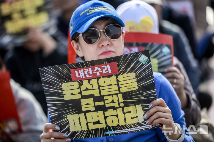 [서울=뉴시스] 정병혁 기자 = 15일 서울 종로구 광화문 동십자각 앞에서 열린 윤석열즉각퇴진 사회대개혁 15차 범시민대행진에서 참가자들이 피켓을 들고 있다. 2025.03.15. jhope@newsis.com