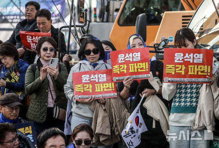 [서울=뉴시스] 정병혁 기자 = 15일 서울 종로구 광화문 동십자각 앞에서 열린 윤석열즉각퇴진 사회대개혁 15차 범시민대행진에서 참가자들이 피켓을 들고 있다. 2025.03.15. jhope@newsis.com