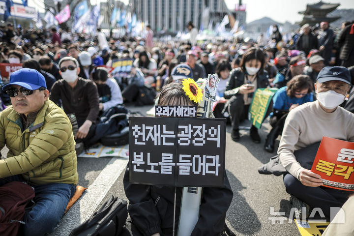 [서울=뉴시스] 정병혁 기자 = 15일 서울 종로구 광화문 동십자각 앞에서 열린 윤석열즉각퇴진 사회대개혁 15차 범시민대행진에서 참가자들이 피켓을 들고 있다. 2025.03.15. jhope@newsis.com