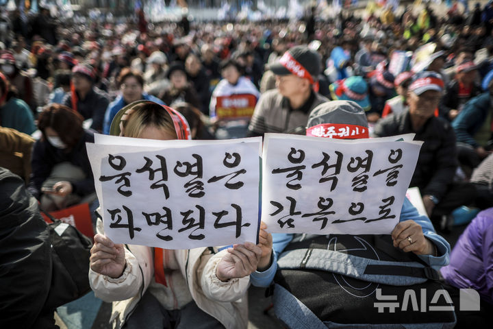 [서울=뉴시스] 정병혁 기자 = 15일 서울 종로구 광화문 동십자각 앞에서 열린 윤석열즉각퇴진 사회대개혁 15차 범시민대행진에서 참가자들이 피켓을 들고 있다. 2025.03.15. jhope@newsis.com