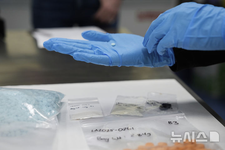 [샌디에이고=AP/뉴시스] 지난 3월 16일(현지 시간) 미국 캘리포니아 샌디에이고의 산이시드로 국경검문소를 방문한 크리스티 놈 미 국토안보부 장관이 펜타닐 정제를 살펴보고 있다. 2025.12..04