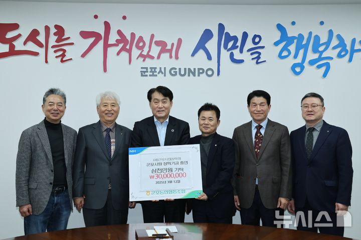 [군포=뉴시스] 이명근 군포농협 조합장(사진 왼쪽 두번째)이 하은호 시장(사진 가운데)에게 장학금을 전달한 가운데 기넘 촬영을 하고 있다. (사진=군포시 제공).2025.03.17.photo@newsis.com