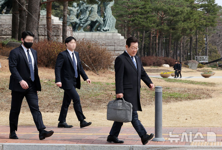 [서울=뉴시스] 조성우 기자 = 암살 위협설이 제기된 이재명(오른쪽) 더불어민주당 대표가 지난 17일 서울 여의도 국회에서 최고위원회의와 비상의원총회에 참석한 뒤 경호원의 보호를 받으며 이동하고 있다.  경찰은 이날 오전 서울 서대문구 경찰청에서 열린 정례 브리핑에서 암살 위협설이 제기된 이 대표에 대한 신변 보호 조치를 당과 협의 중이라고 밝혔다. 2025.03.17. xconfind@newsis.com