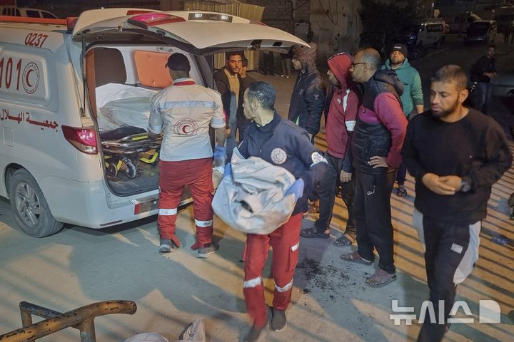 [칸유니스=AP/뉴시스] 18일(현지 시간) 가자지구 남부 칸유니스에서 구급대원들이 이스라엘 공습으로 사망한 희생자를 병원으로 옮기고 있다. 휴전 협상 지역 속 이스라엘은 이날 새벽 가자지구 전역을 기습 공습했다. 2025.03.18.