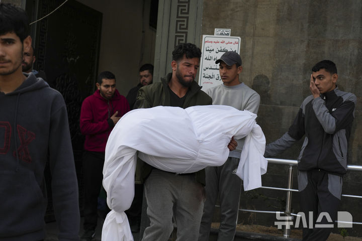 [가자시티=AP/뉴시스] ﻿﻿이스라엘이 휴전 2달 만에 가자지구에 대한 대규모 공습을 재개한 가운데 유엔이 공습에 충격을 받았다면서 공격을 멈출 것을 호소했다. 사진은 18일(현지 시간) 가자지구 가자시티에서 팔레스타인 남성이 이스라엘의 공습으로 숨진 희생자 시신을 시파 병원으로 옮기고 있다. 2025.03.18