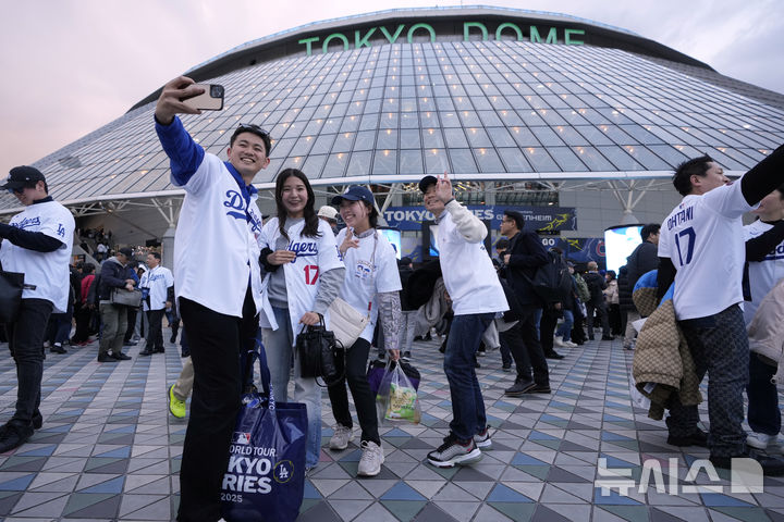 [도쿄=AP/뉴시스] 지난달 18일 일본 도쿄돔에서 열리는 2025 메이저리그(MLB) 개막전 '도쿄 시리즈' 로스앤젤레스(LA) 다저스와 시카고 컵스의 경기장을 찾은 야구팬들이 셀카를 찍고 있다. 이날 오타니 쇼헤이는 5타수 2안타 2득점을 기록하며 팀의 4-1 승리를 이끌었다. 2025.03.19.
