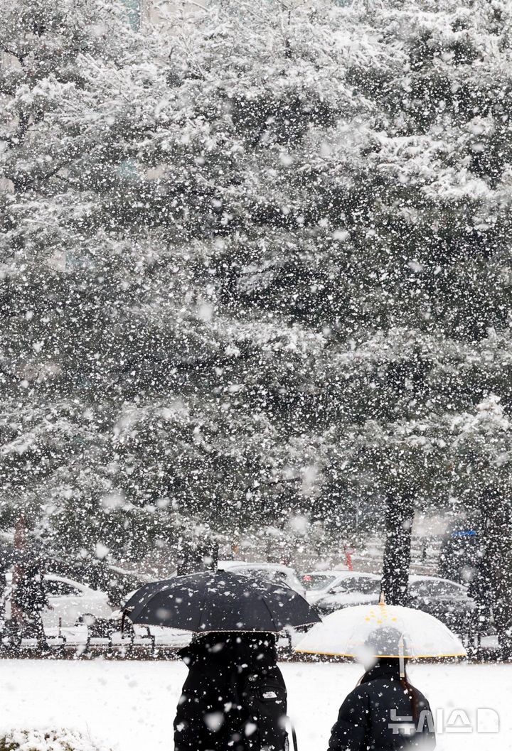 [서울=뉴시스] 조성봉 기자 = 서울과 경기도 등 수도권에 대설주의보가 내려진 18일 오전 서울 영등포구 여의도 인근에서 시민들이 내리는 눈을 맞으며 출근길 발걸음을 재촉하고 있다. 2025.03.18. suncho21@newsis.com