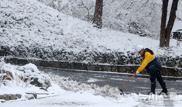 [서울=뉴시스] 김혜진 기자 = 눈이 내리는 지난 3월 18일 오전 서울 중구 거리에서 중구 관계자가 제설 작업을 하고 있다. 2025.03.18. jini@newsis.com