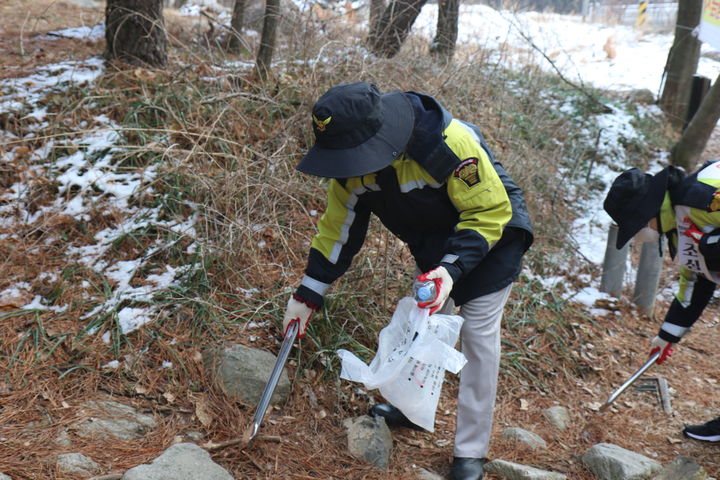 [완주=뉴시스] 전북의용소방대원이 19일 전북 완주군 모악산 일대에서 진행된 산불예방 캠페인 및 환경정화 활동 행사에서 등산로에 버려진 쓰레기를 줍고 있다. (사진=전북도소방본부 제공) 2025.03.19. photo@newsis.com *재판매 및 DB 금지