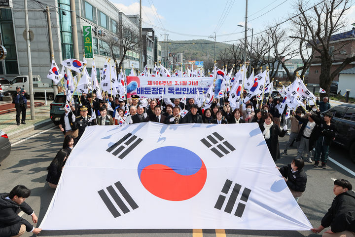 [고성(경남)=뉴시스] 신정철 기자= 경남 고성군은 19일, 3.1운동창의탑보존위원회(위원장 최근호) 주관으로 회화면 배둔리 3·1운동 창의탑 행사장에서 고성군 내 독립애국지사 유족 및 보훈단체, 기관·사회단체, 학생 등을 비롯해 군민 350여 명이 참석한 가운데 ‘제106주년 3·1절 배둔장터 독립 만세운동 기념행사’를 개최했다.사진은 참가자들이 창의탑을 출발해 회화면 배둔시장을 지나는 길을 함께 행진하며 106년 전 배둔장터에 울려 퍼진 대한독립 만세운동을 재현하고 있다.(사진=고성군 제공).2025.03.19. photo@newsis.com *재판매 및 DB 금지