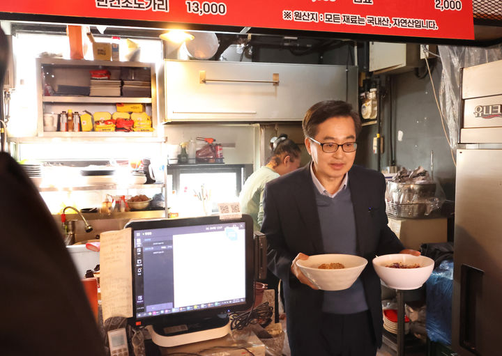[수원=뉴시스] 김동연 경기도지사가 20일 낮 12시 수원시 영통구에 위치한 음식점에서 점심식사로 주문한 비빔국수를 들고오고 있다. (사진=경기도 제공) 2025.03.20. photo@newsis.com *재판매 및 DB 금지