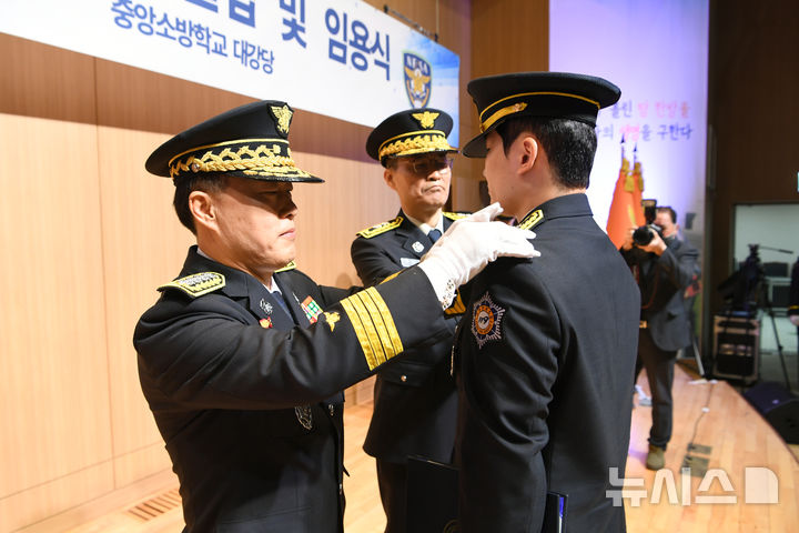 [서울=뉴시스] 지난 21일 충남 공주 중앙소방학교 대강당에서 제30기 소방간부후보생 졸업 및 임용식이 열린 가운데 허석곤 소방청장이 졸업생에게 계급장을 달아주고 있다. (사진=소방청 제공) 2025.3.21 photo@newsis.com