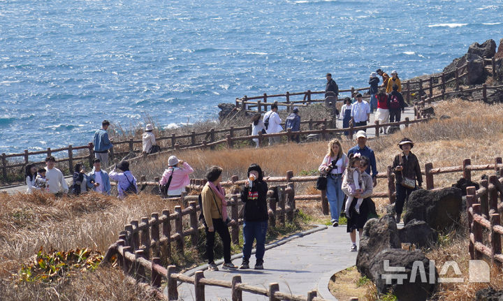 [서귀포=뉴시스] 우장호 기자 = 낮 기온이 25도에 육박하는 23일 제주 서귀포시 성산읍 섭지코지를 찾은 관광객들이 완연한 봄기운을 만끽하며 산책을 즐기고 있다. 2025.03.23. woo1223@newsis.com