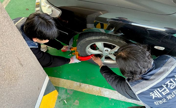 [창녕=뉴시스] 창녕군 영치 상설기동반이 외국인 대포차에 차량 족쇄를 채우고 있다. (사진= 창녕군 제공) 2025.03.24. photo@newsis.com *재판매 및 DB 금지