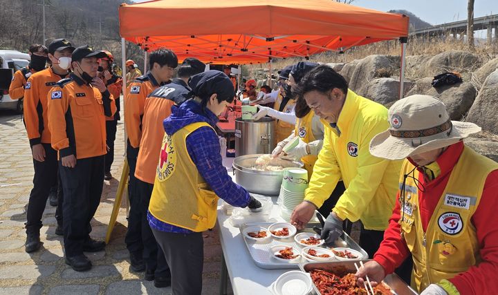 [울산=뉴시스] 박수지 기자 = 대한적십자사 울산지사가 24일 울주군 산불 현장에서 구호활동을 전개하고 있다. (사진=울산지사 제공) 2025.03.24. photo@newsis.com *재판매 및 DB 금지