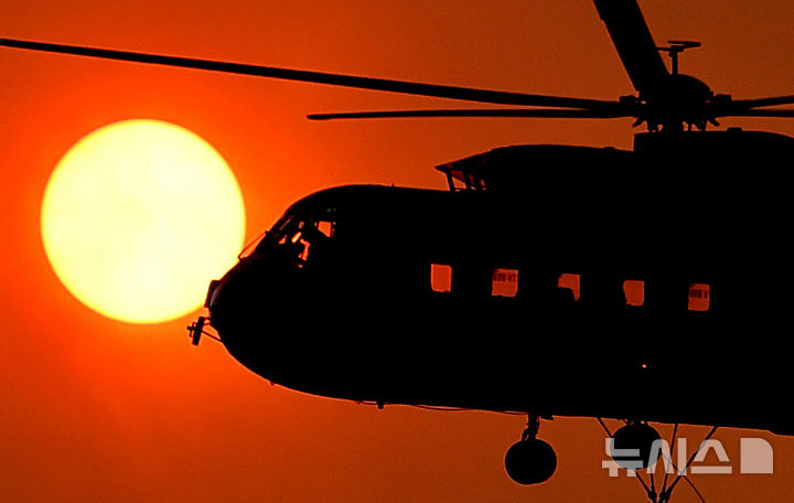 [의성=뉴시스] 이무열 기자 = 경북 의성군 산불 발생 사흘째인 24일 점곡면 명고리 한 야산에서 산불진화헬기가 태양을 지나고 있다. 2025.03.24. lmy@newsis.com