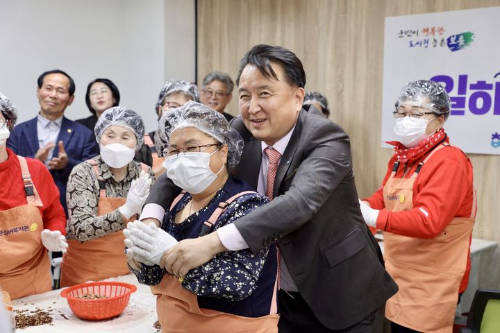 [보은=뉴시스] 김영환 충북지사가 25일 보은군 보은읍 실버복지관 '일하는 밥퍼' 현장에 방문해 농산물 전처리 작업을 하는 노인을 안으며 밝게 웃고 있다. 11개 시군을 순방 중인 김 지사는 이날 보은지역 대추 재배·가공업 청년농부의 사업장과 충북소방교육대 조성 예정지, 장애인 친화작업장 ‘일하는 밥퍼’ 현장 등을 둘러봤다. (사진=보은군 제공) 2025.03.25. photo.newsis.com *재판매 및 DB 금지