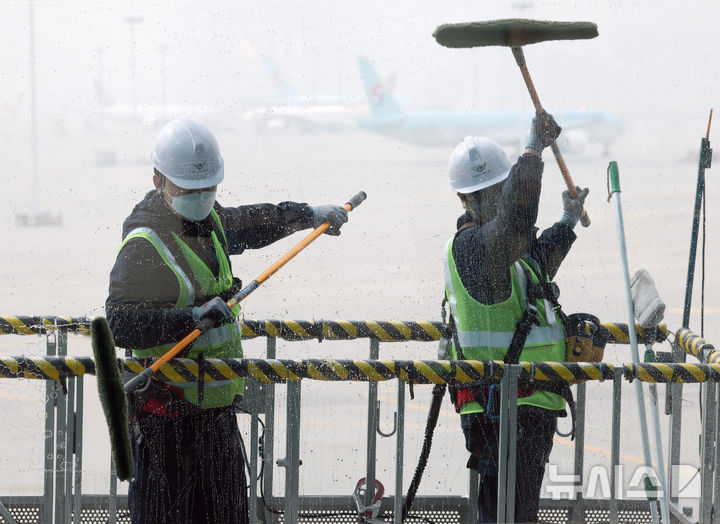 [인천공항=뉴시스] 김명년 기자 = 25일 오전 인천국제공항 제2여객터미널에서 환경미화원들이 터미널 유리 외벽 물청소를 하고 있다. 대청소 작업은 인천공항 시설 전반을 대상으로 오는 29일까지 진행되며, 매일 800여명의 인력과 200여 대의 장비가 투입된다. 2025.03.25. kmn@newsis.com