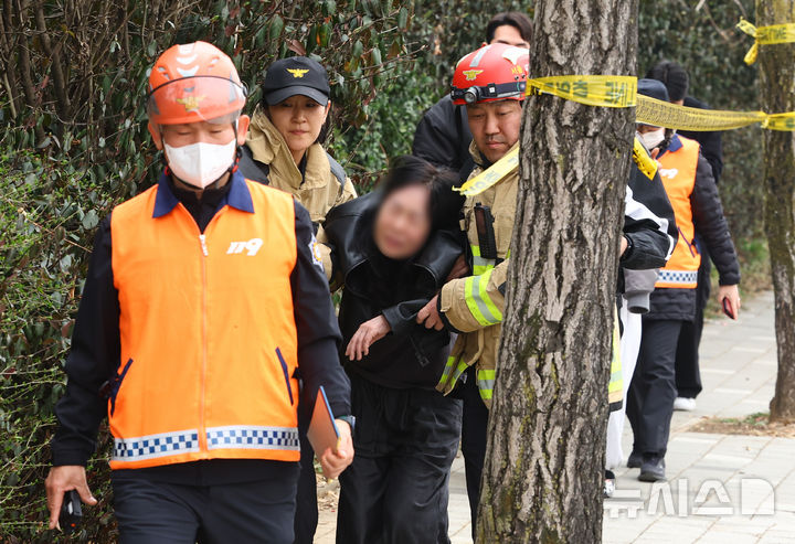 [서울=뉴시스] 황준선 기자 = 25일 오전 서울 강동구 명일초등학교 인근 도로에서 전날 발생한 싱크홀(땅 꺼짐) 사고 현장에 매몰돼 숨진 오토바이 운전자의 유가족이 소방대원의 부축을 받으며 이동하고 있다. 2025.03.25. hwang@newsis.com