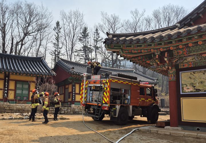 [청송=뉴시스] 119산불특수대응단이 청송 소재 천년고찰 대전사에서 산불화재 방어를 위해 대기하고 있다. 2025.03.26. (사진=경북소방본부 제공) photo@newsis.com *재판매 및 DB 금지