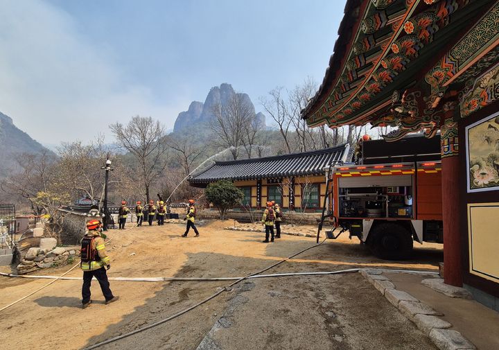 [청송=뉴시스] 119산불특수대응단이 청송 소재 천년고찰 대전사에서 산불화재 방어를 위해 대기하고 있다. 2025.03.26. (사진=경북소방본부 제공) photo@newsis.com *재판매 및 DB 금지