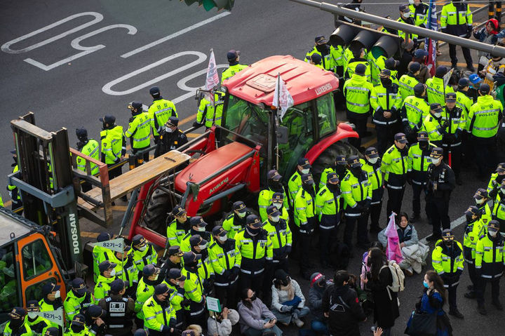 26일 서울 종로구 자하문로에서 경찰들이 전국농민회총연맹 소속 트랙터를 둘러싸고 있는 가운데 시민단체와 대치하고 있다. (사진=비상행동 제공) 2025.03.26.