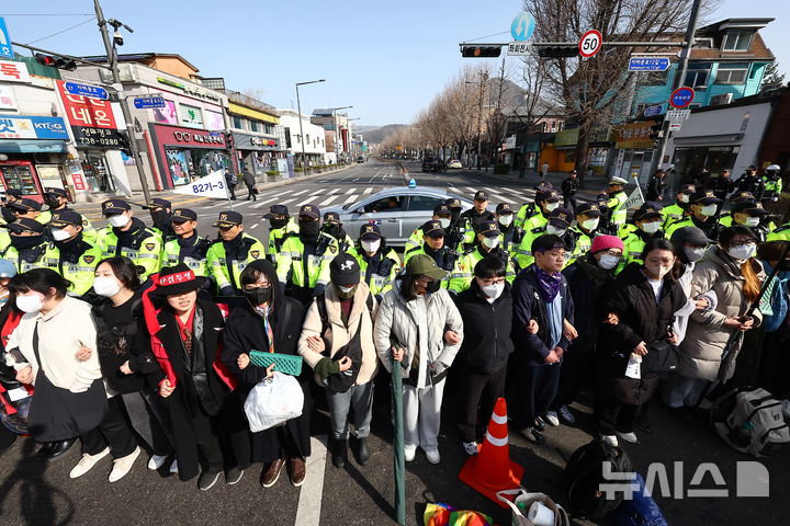 [서울=뉴시스] 김근수 기자 = 26일 서울 종로구 자하문로 인근에서 경찰들이 전국농민회총연맹(전농) 소속 트랙터를 둘러싸고 있는 가운데 시민단체 회원들과 대치하고 있다. 2025.03.26. ks@newsis.com