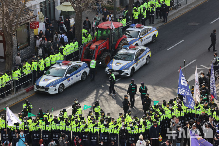 [서울=뉴시스] 김근수 기자 = 26일 서울 종로구 자하문로에서 경찰들이 전국농민회총연맹(전농) 소속 트랙터를 둘러싸고 있는 가운데 시민단체 회원들과 대치하고 있다. 2025.03.26. ks@newsis.com