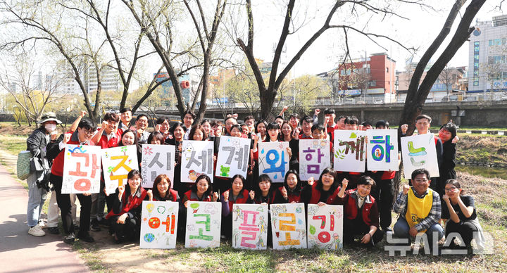 광주신세계 임직원들이 26일 광주천변 일대에서 에코 플로깅(걸으며 쓰레기 줍기) 활동을 펼친 후 기념사진을 찍고 있다. (사진=광주신세계 제공) 2025.03.26. photo@newsis.com *재판매 및 DB 금지