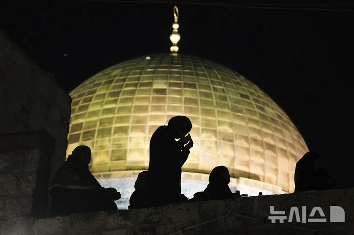 [예루살렘=AP/뉴시스] 팔레스타인 무슬림 여성들이 2025년 3월 26일 라마단 성월 27번째 날에 해당하는 ‘권능의 밤’(라일라트 알 카드르)을 맞아 예루살렘 구시가지 알아크사 모스크 단지 내 바위 돔 사원 앞에서 기도하고 있다. 올해엔 라마단 기간에도 이스라엘이 사원문을 봉쇄하고 참배를 막아 ' 이슬람 8개국 외무장관이 3월 11일 비난 성명을 발표했다. 2026. 03. 12. 